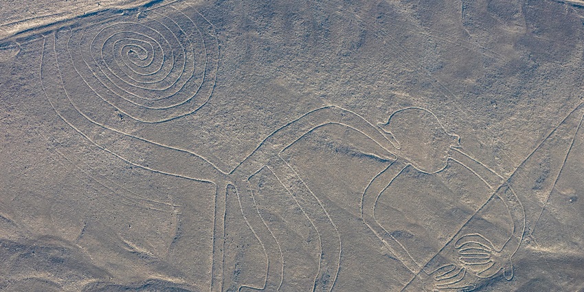 Fly over the mysterious Nazca Lines, ancient geoglyphs etched into the desert floor.