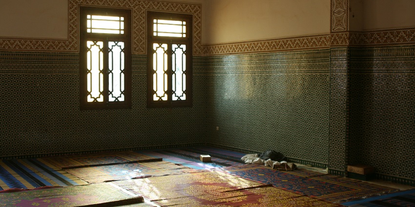 Interior of the Niamey Grand Mosque with a couple of windows and multiple carpets on the floor