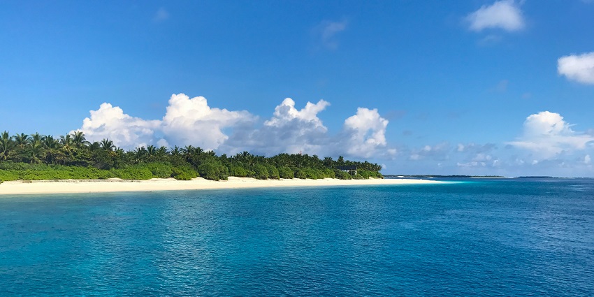 Beautiful tropical beach at Nosy Iranja with white sand, clear blue water, and green palm trees, one of the Islands in Madagascar.