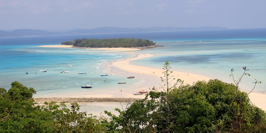 A small island with green trees, Nosi Tanikely is surrounded by clear blue ocean water, one of the top islands in Madagascar.