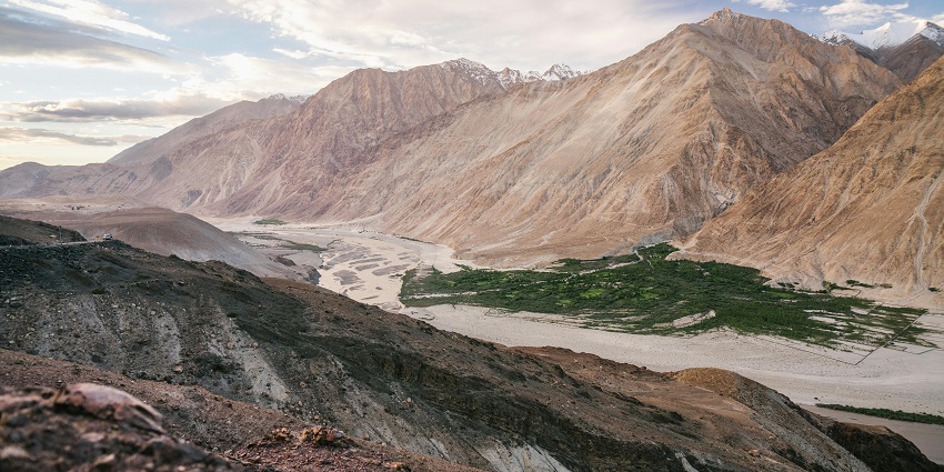 Lush valley in Ladakh with dunes and green villages amidst the desert.
