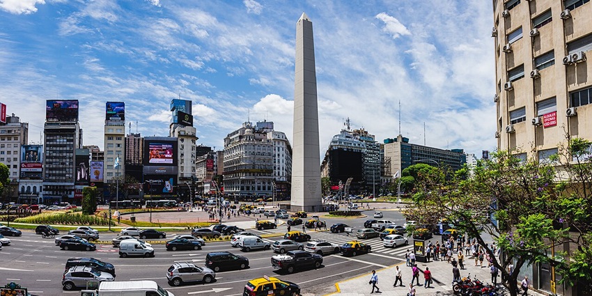 Obelisco de Buenos Aires is surrounded by busy roads with multiple vehicles and people walking, one of the top monuments in Argentina.
