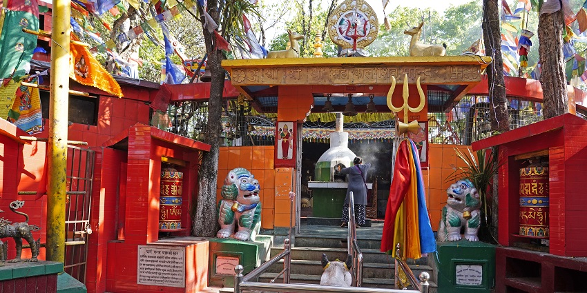 Exterior view of Mahakal Temple in Darjeeling surrounded by trees and prayer flags