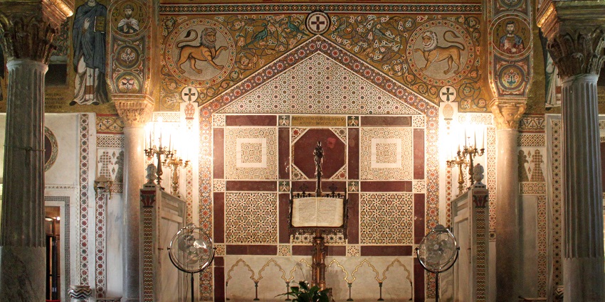 Interior of Palatine Chapel in Palermo with detailed designs on the walls and warm lighting