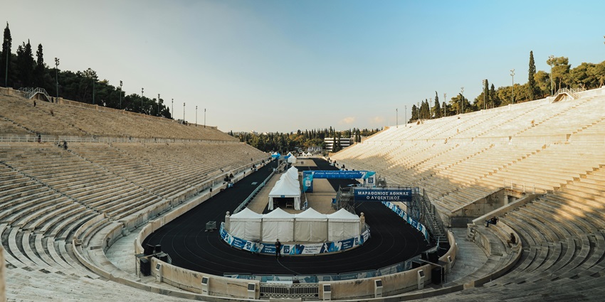 A large ancient stadium structure surrounded by trees, one of the historical Places in Athens Greece.