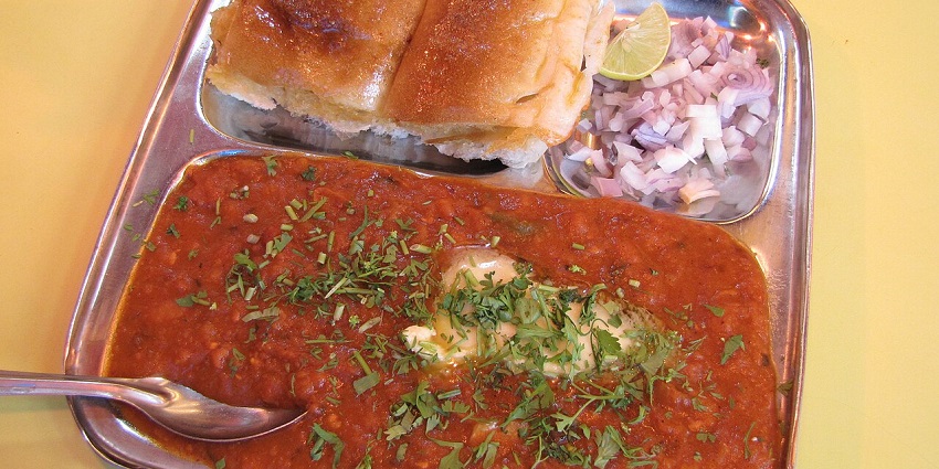 Butter-toasted buns served with spicy mashed vegetable curry, topped with chopped onions and lemon
