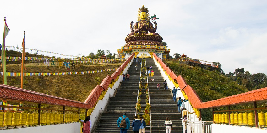 Giant Buddha statue at Pelling Sky Walk with panoramic mountain views and cloudy sky.