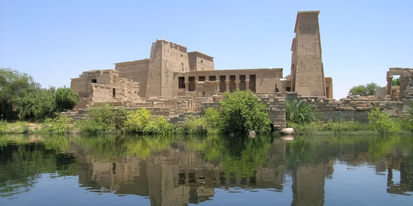 Tranquil island temple dedicated to goddess Isis, accessed by boat and surrounded by Nile River waters.