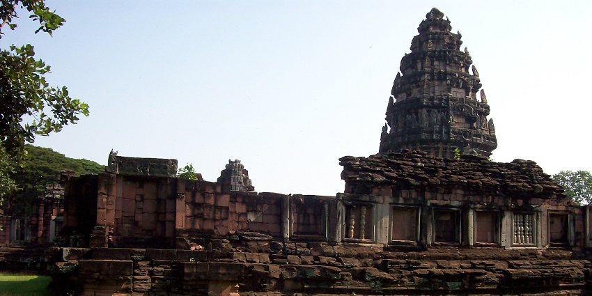 Phimai historical park in Thailand, with old ruined architecture of a temple and greenery.
