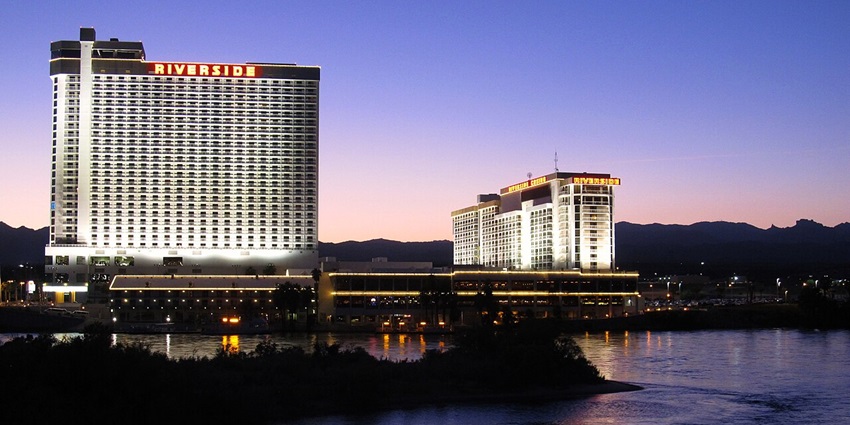A breathtaking view of a huge building next to a body of water during the night.