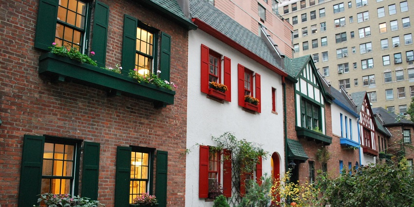 Pomander Walk with multiple vibrant houses, flower pots near the windows and green plants