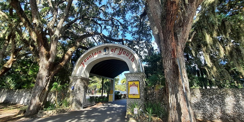 Entrance gate of Ponce de León’s Fountain of Youth Archaeological Park with tall trees