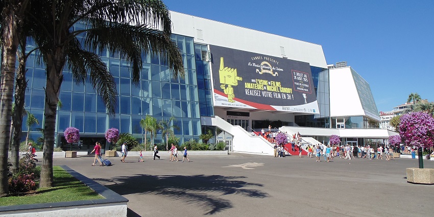 Visitors striking poses on the famous red carpet steps of Palais des Festivals in Cannes.