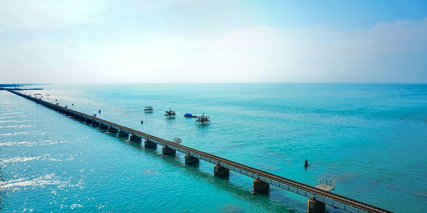 Scenic view of fishing boats anchored near the shore along the turquoise waters.
