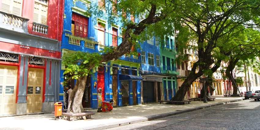 Street in Recife Antigo with multiple vibrant, colourful buildings, green trees