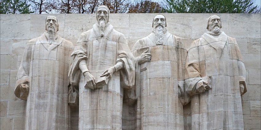 Le Mur des Réformateurs monument in Geneva, featuring large stone statues of four religious reformers, one of the famous monuments in Switzerland.