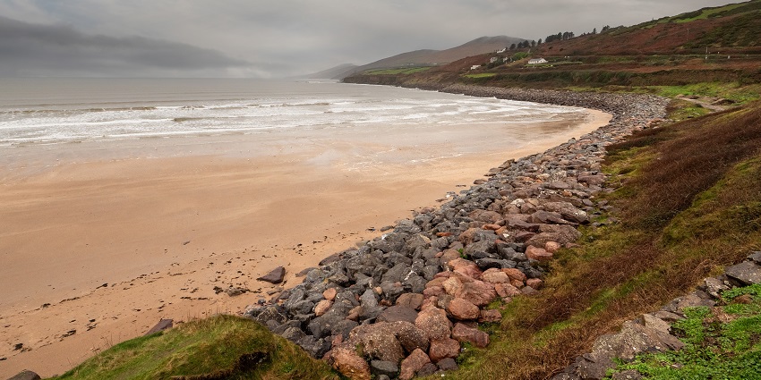 Surfing a wave off the scenic coastline, one of the best things to do in Dingle.