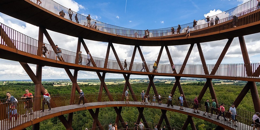Spiral walkway rising above treetops, providing panoramic forest views from a stunning structure.