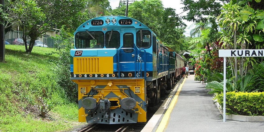 A train crossing a stone bridge in dense rainforest, scenic things to do in Far North Queensland.

