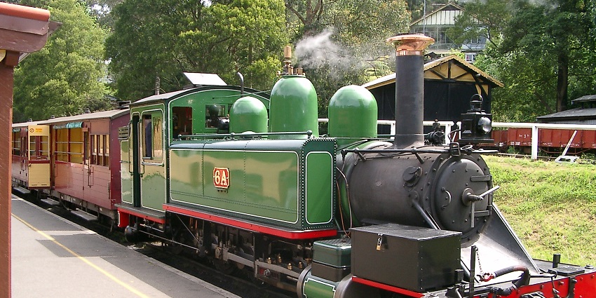 Classic train chugging through dense forest, an iconic journey among things to do in Victoria.