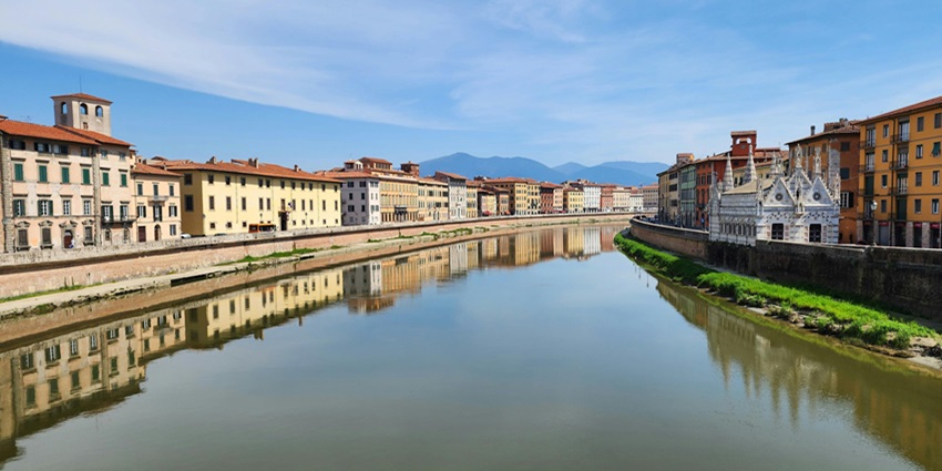 A scene of the Arno River in Pisa, Italy, famous for gondola rowing along the calm waters.

