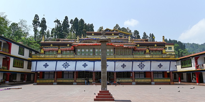 A serene view of Rumtek Dharma Chakra, Gangtok, with colourful facade and ornate golden roof.
