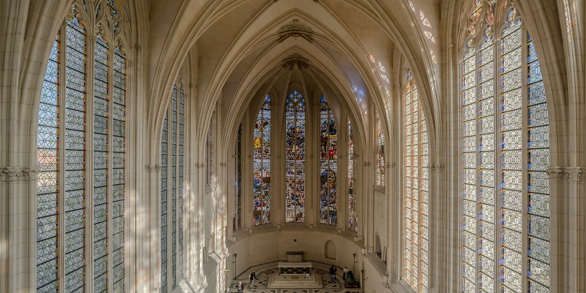 Interior of Sainte-Chapelle with soaring stained-glass windows in vibrant hues.