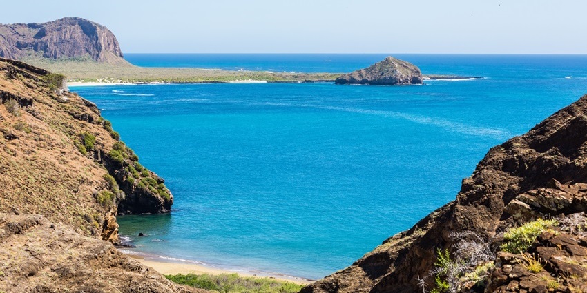 Blue waters of the sandy beaches at the small island in Ecuador under the clear sky.