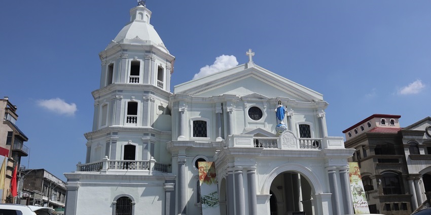 San Fernando cathedral church with white architecture and a Virgin Mary statue on top