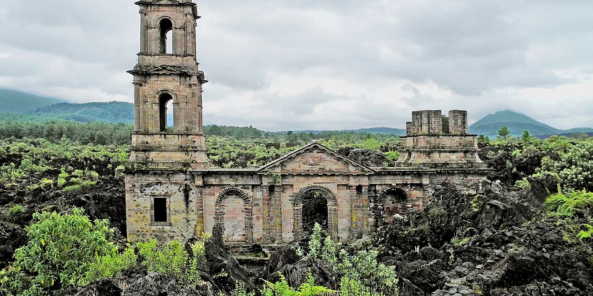 Ruins of San Juan Parangaricutiro church with old architecture and a cross on top of the church