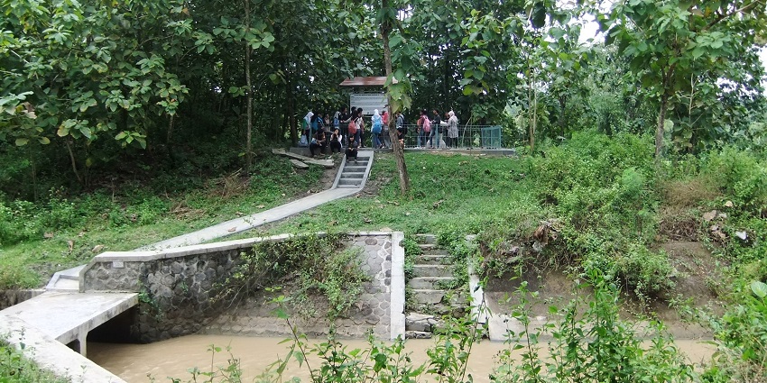 A group of people gathered at a historical site in a forest near a small river channel.
Viewers of this file can see comments and suggestions
