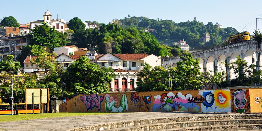 Colourful street art on a wall with historic buildings, and arches in Rio de Janeiro