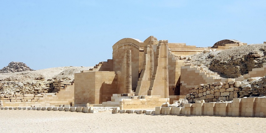 Entrance to the Step Pyramid complex in Saqqara with ancient stone columns and remains.