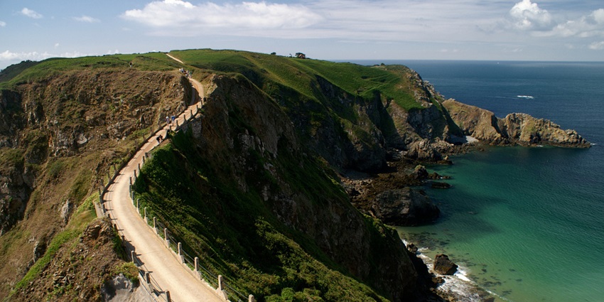 A narrow cliffside path winds along the coast of Sark Island in the Channel Islands.