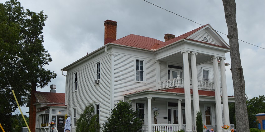 Historical complex showcasing industrial-era buildings and a Victorian-style residence.