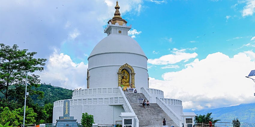 White Shanti Stupa shining against a blue sky, symbolising peace and panoramic views.