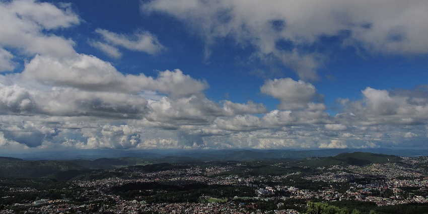 Shillong Peak viewpoint with distant buildings in Shillong city, mountains and clouds , one of the best places to visit in Shillong in January.