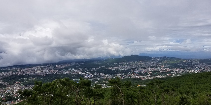 Shillong view point with distant buildings, houses of Shillong city, green trees and mountains