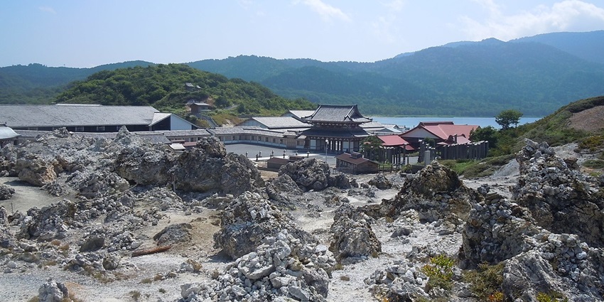 Mount Osore with traditional buildings of Japanese architect and distant green hills