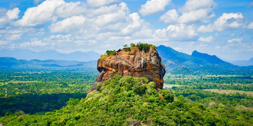 Aerial view of Sigiriya rock fortress in Sri Lanka, surrounded by green forests and ancient ruins, one of the famous monuments in Sri Lanka.