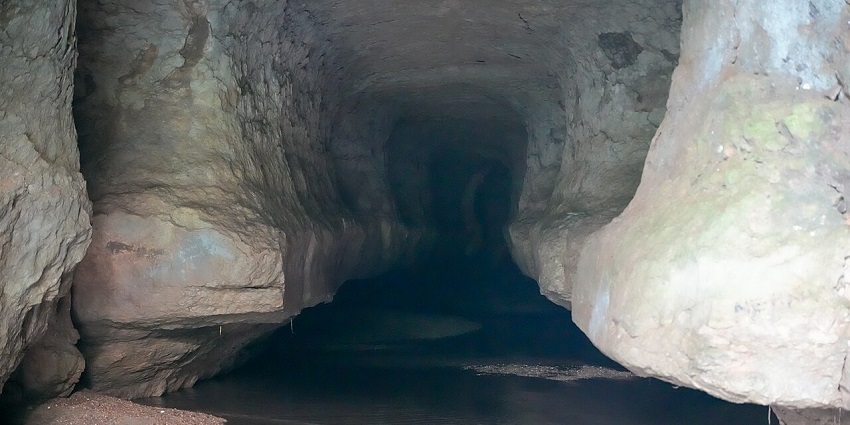 Inside of Siju caves with unique rock formations, flat floor surface and sands on side.