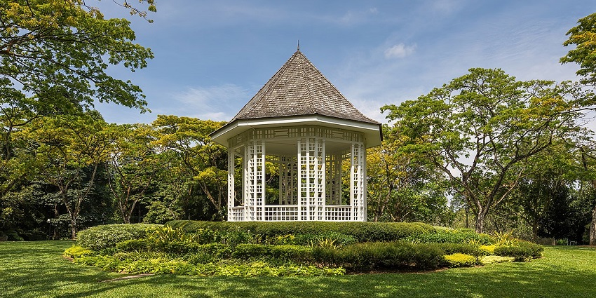 Bandstand surrounded by lush green trees on a sunny afternoon at Singapore Botanic Gardens, one of the best places to visit in Singapore in September.
