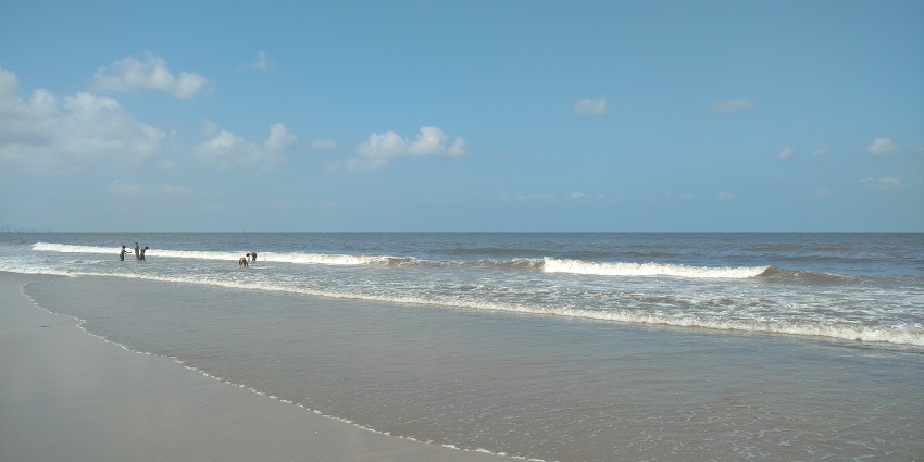 Juhu beach with food stalls serving bhel puri, vada pav, and gola by the shoreline.