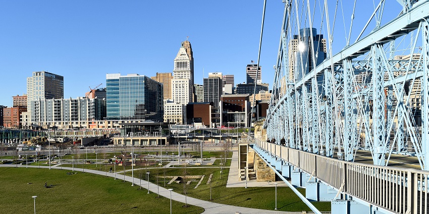 Families and couples enjoying riverside views, fountains, and green lawns at Smale Riverfront Park.