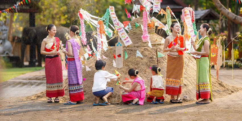 Asian people wearing Thai dress traditional playing splash water during Songkran festival and Thai elephant at temple