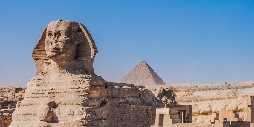 Massive limestone statue with the body of a lion and the head of a pharaoh, guarding the pyramids of Giza.