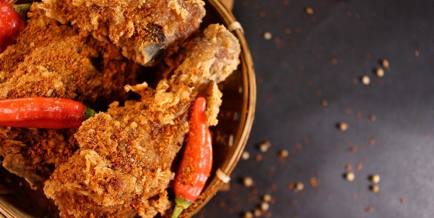 Plate of spicy Nashville hot chicken served at a cosy local restaurant.