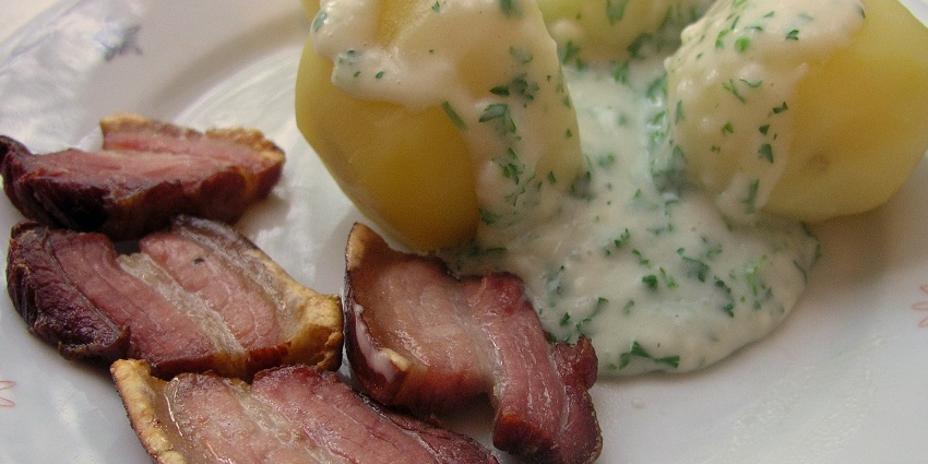 An image of Crispy stegt flæsk with parsley sauce, a traditional and famous food in Denmark.