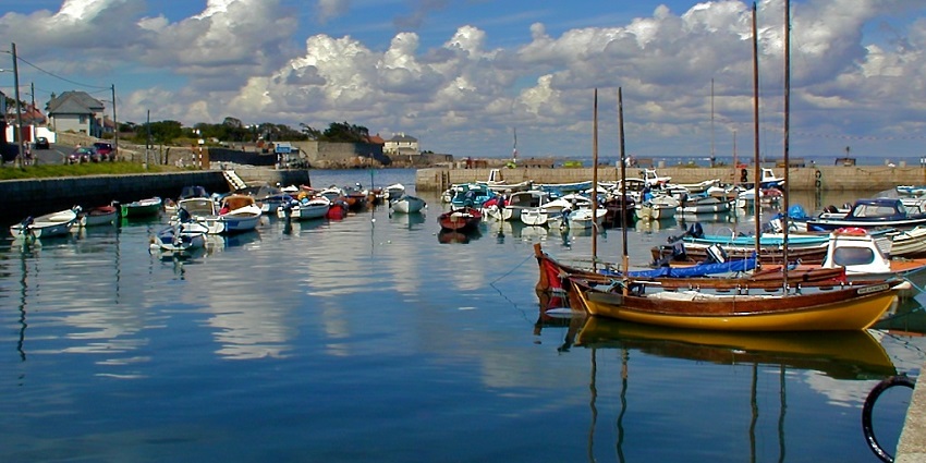 Charming harbour where fishing boats dock and locals gather for fresh sea air and scenic walks.