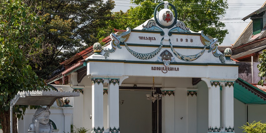 White traditional pavilion with ornate carvings and columns at Taman Sari in Yogyakarta.